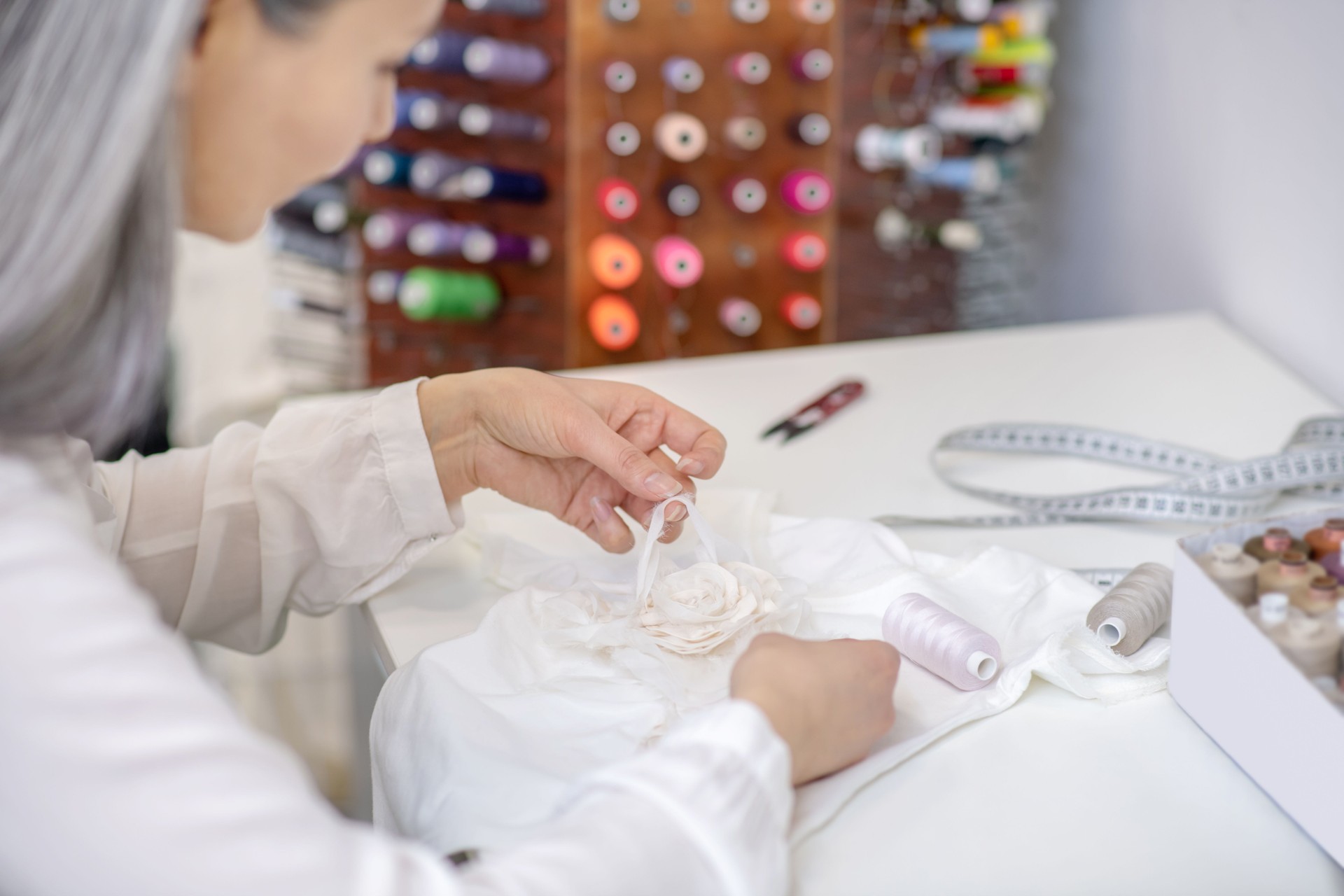 Woman repairing clothes at table in workshop